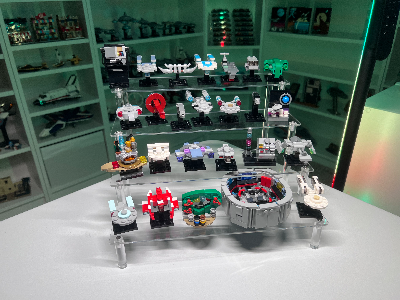 High-angle view of 25 micro LEGO models on a four-tiered acrylic stand, featuring diverse sci-fi and structural builds.